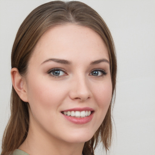 Joyful white young-adult female with long  brown hair and blue eyes