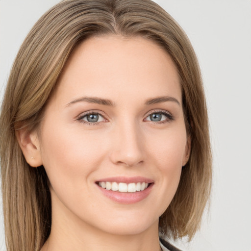 Joyful white young-adult female with long  brown hair and green eyes