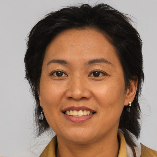 Joyful asian adult female with medium  brown hair and brown eyes