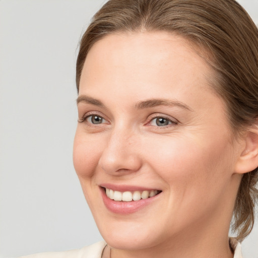 Joyful white young-adult female with medium  brown hair and grey eyes