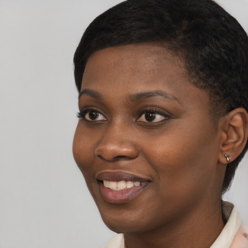 Joyful black young-adult female with short  black hair and brown eyes