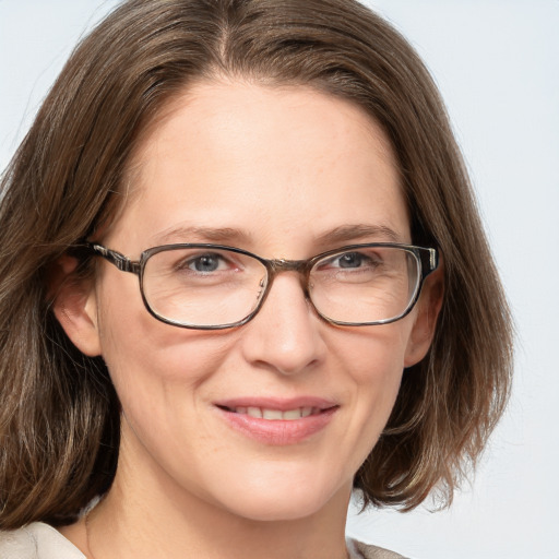 Joyful white adult female with medium  brown hair and grey eyes