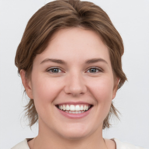 Joyful white young-adult female with medium  brown hair and grey eyes