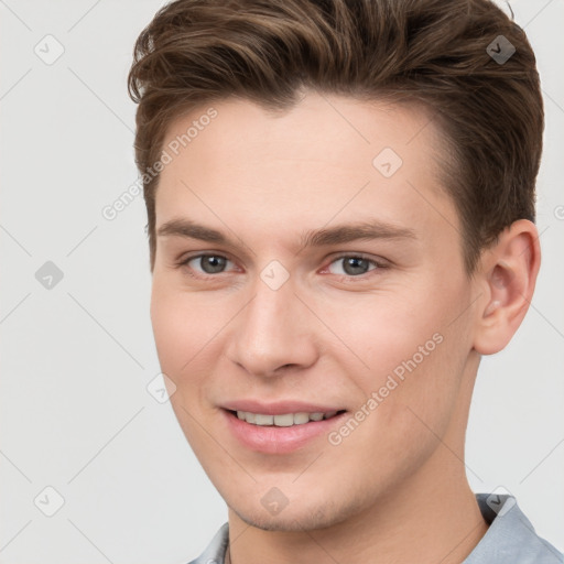 Joyful white young-adult male with short  brown hair and grey eyes