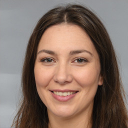 Joyful white adult female with long  brown hair and brown eyes