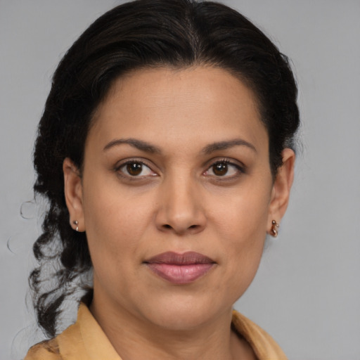 Joyful latino adult female with medium  brown hair and brown eyes