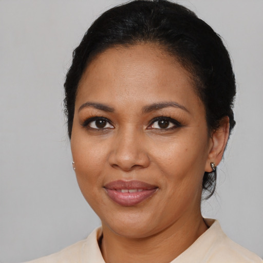 Joyful latino adult female with medium  black hair and brown eyes