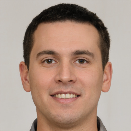 Joyful white young-adult male with short  brown hair and brown eyes