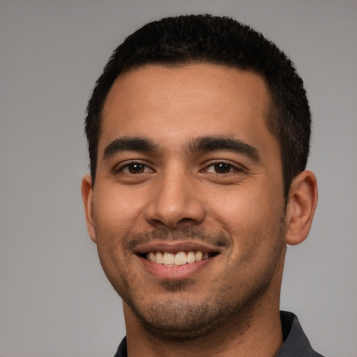 Joyful latino young-adult male with short  black hair and brown eyes