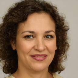 Joyful white young-adult female with medium  brown hair and green eyes