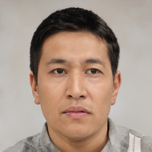Neutral asian adult male with short  black hair and brown eyes