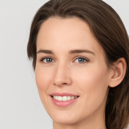 Joyful white young-adult female with long  brown hair and green eyes