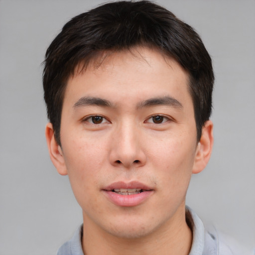 Joyful asian young-adult male with short  brown hair and brown eyes