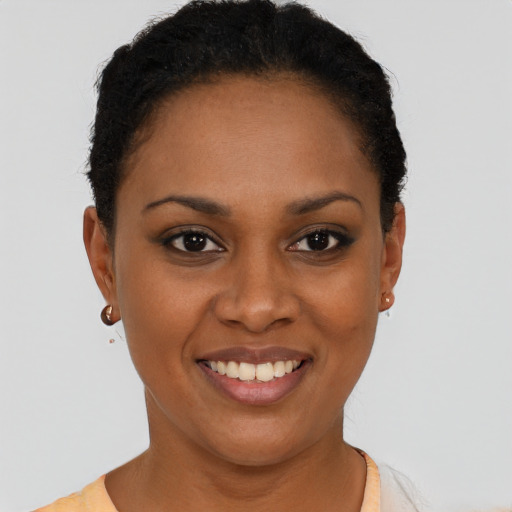 Joyful black young-adult female with short  black hair and brown eyes