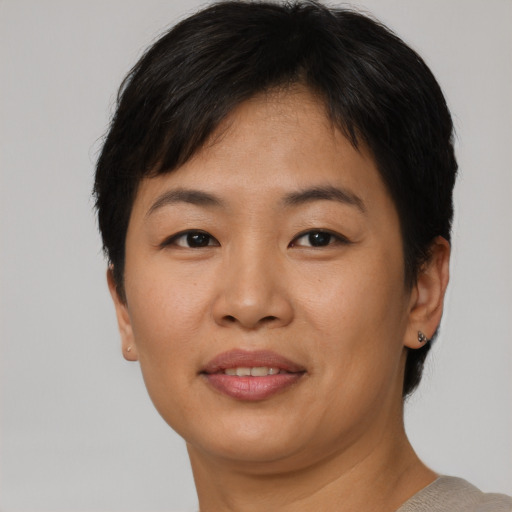 Joyful asian young-adult female with short  brown hair and brown eyes