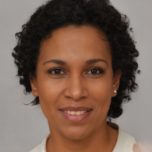 Joyful black adult female with short  brown hair and brown eyes