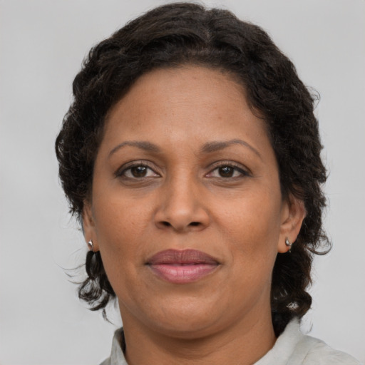 Joyful black adult female with medium  brown hair and brown eyes