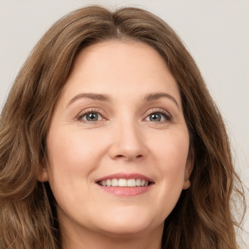 Joyful white young-adult female with long  brown hair and green eyes