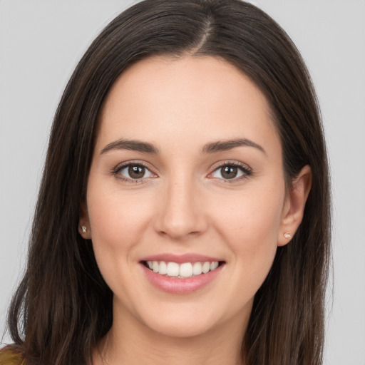 Joyful white young-adult female with long  brown hair and brown eyes