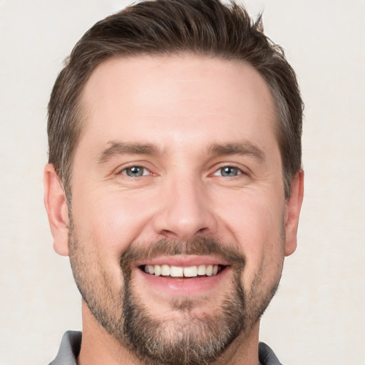 Joyful white young-adult male with short  brown hair and brown eyes