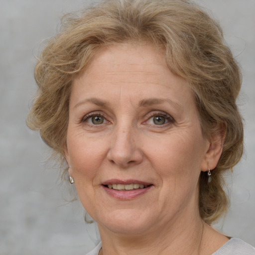 Joyful white adult female with medium  brown hair and blue eyes