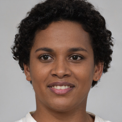 Joyful black young-adult female with short  brown hair and brown eyes