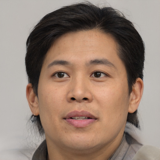 Joyful asian adult male with short  brown hair and brown eyes