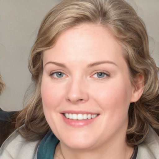 Joyful white young-adult female with medium  brown hair and blue eyes