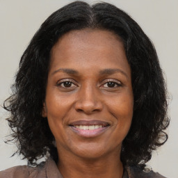 Joyful black adult female with medium  brown hair and brown eyes