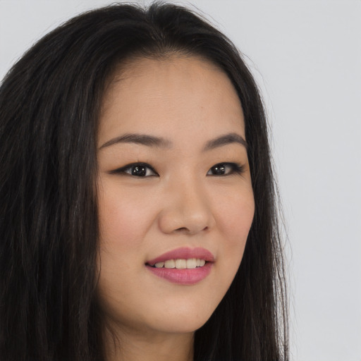 Joyful asian young-adult female with long  brown hair and brown eyes