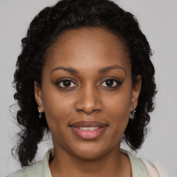 Joyful black young-adult female with long  brown hair and brown eyes