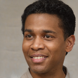 Joyful black young-adult male with short  brown hair and brown eyes