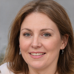 Joyful white adult female with medium  brown hair and grey eyes