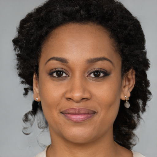 Joyful black adult female with medium  brown hair and brown eyes