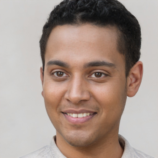 Joyful black young-adult male with short  brown hair and brown eyes