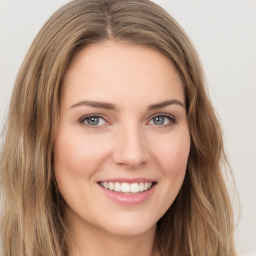 Joyful white young-adult female with long  brown hair and green eyes