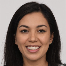 Joyful latino young-adult female with long  brown hair and brown eyes