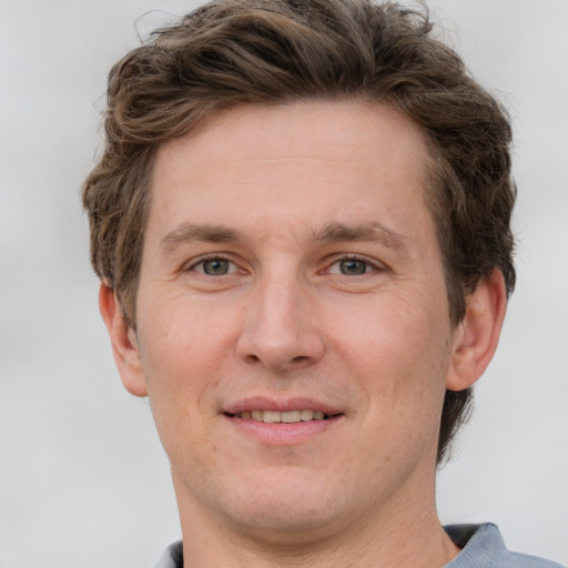 Joyful white adult male with short  brown hair and grey eyes