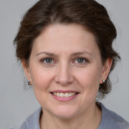 Joyful white adult female with medium  brown hair and grey eyes