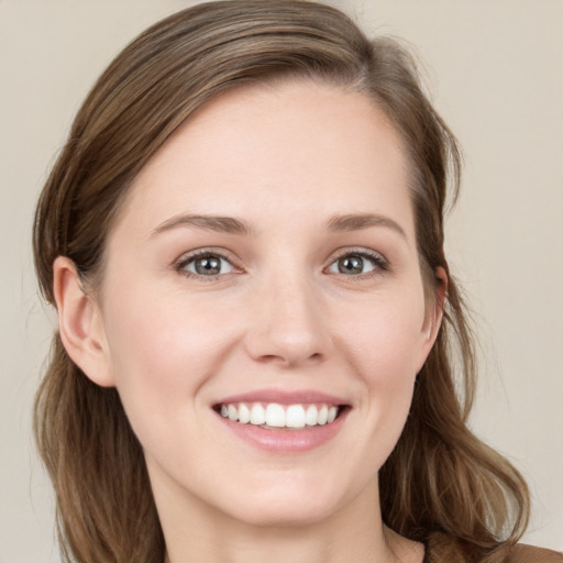 Joyful white young-adult female with long  brown hair and grey eyes