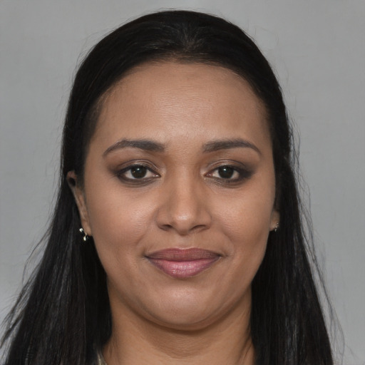 Joyful black young-adult female with long  brown hair and brown eyes