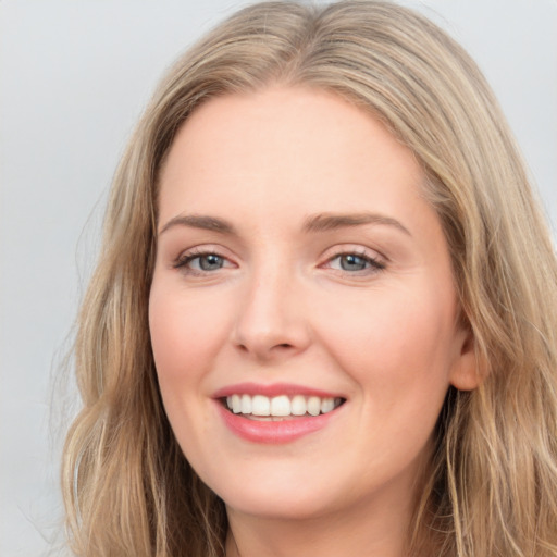 Joyful white young-adult female with long  brown hair and blue eyes