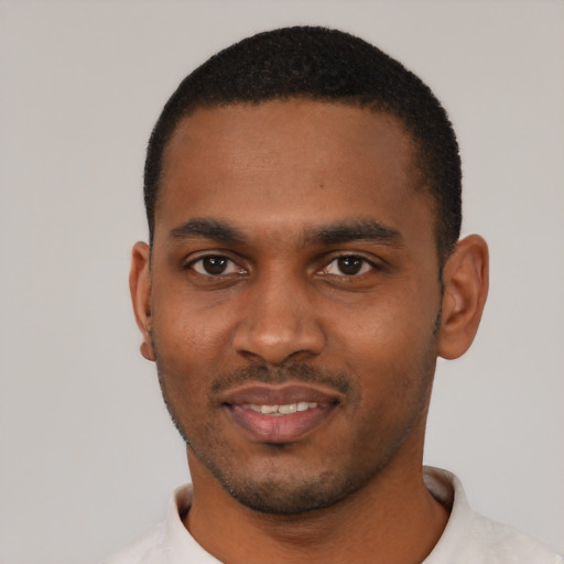 Joyful black young-adult male with short  black hair and brown eyes
