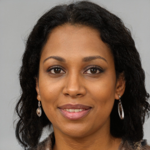 Joyful black adult female with medium  brown hair and brown eyes