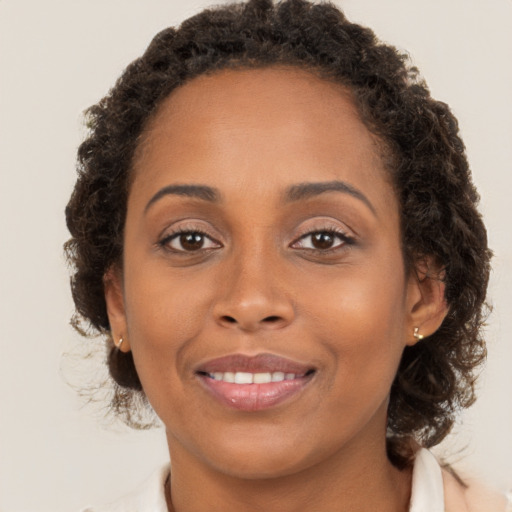 Joyful black young-adult female with medium  brown hair and brown eyes