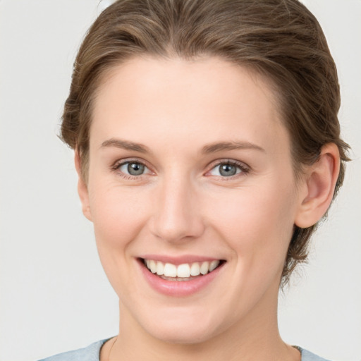 Joyful white young-adult female with short  brown hair and grey eyes