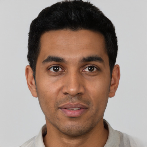 Joyful latino young-adult male with short  black hair and brown eyes