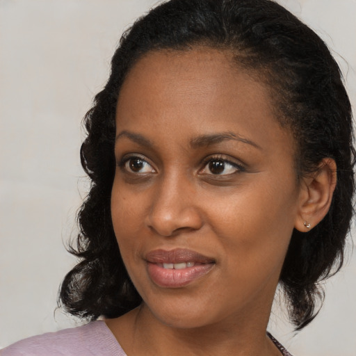 Joyful black young-adult female with medium  brown hair and brown eyes