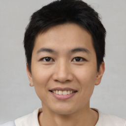 Joyful asian young-adult male with short  brown hair and brown eyes