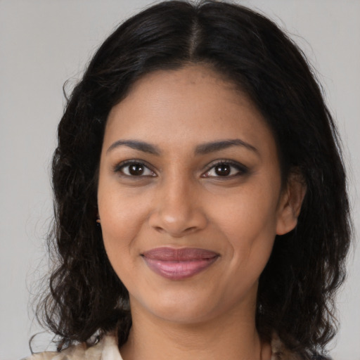 Joyful black young-adult female with long  brown hair and brown eyes